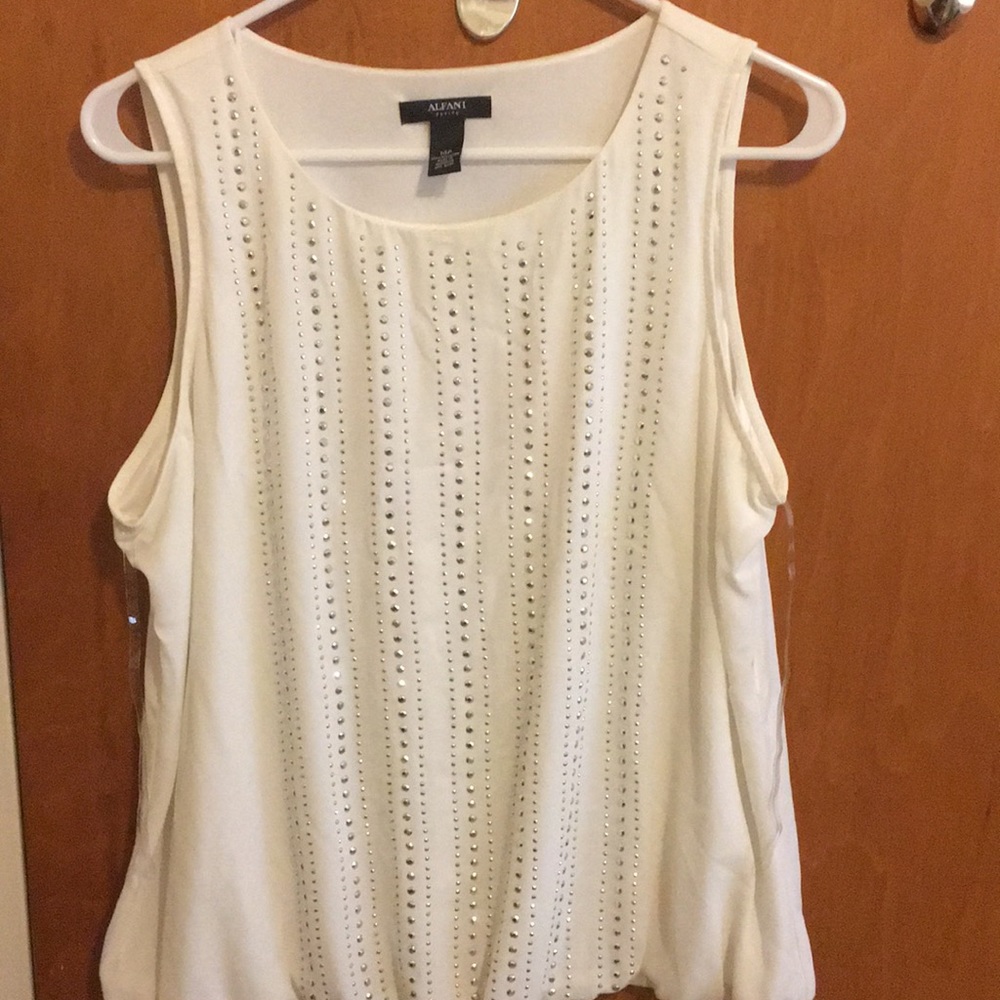 Sleeveless cream blouse with studs on it